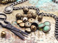 Metal beads,buttons,chain and scissors on retro background